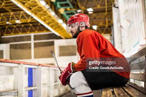 ijshockeyspeler zittend op een bankje - side lines stockfoto's en -beelden