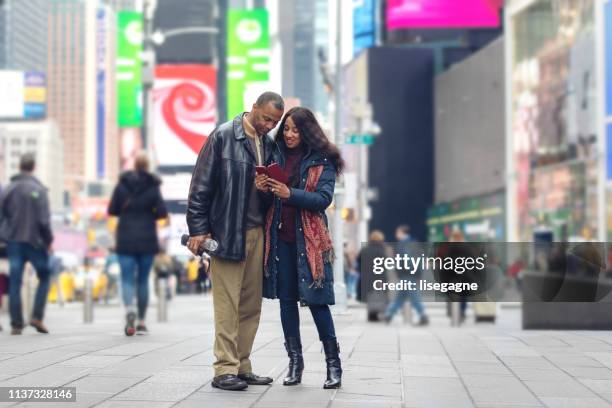 reife paar auf time square - time square new york stock-fotos und bilder