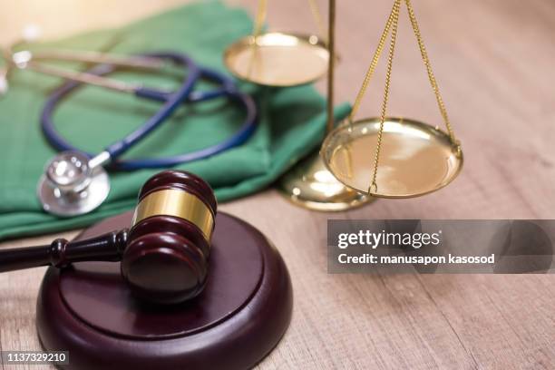 gavel and stethoscope in background. medical laws and legal concept. - legislação imagens e fotografias de stock