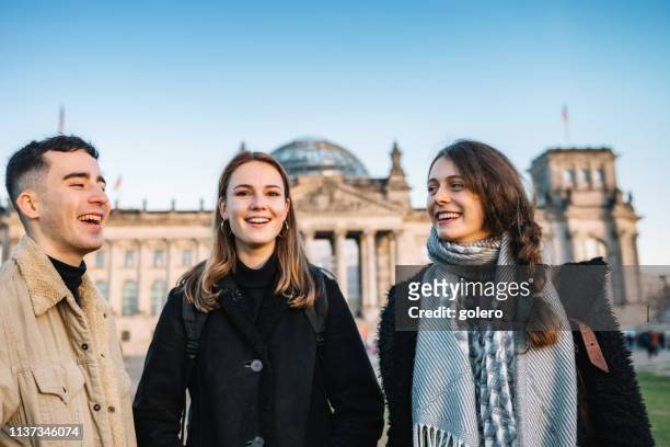 drie jonge mensen voor berlijn reichstag - berlin stockfoto's en -beelden
