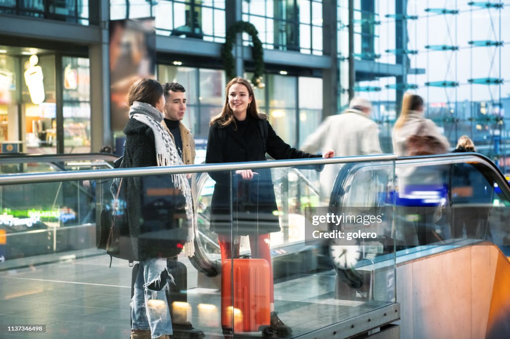 Three young travellers inside of train station