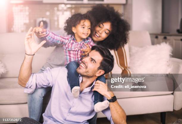 speelse jonge familie - mum sitting down with baby stockfoto's en -beelden
