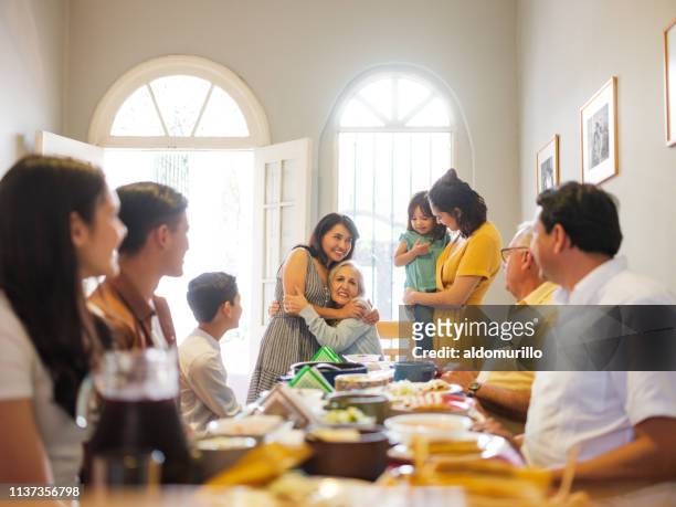 famiglia messicana a pranzo abbraccia nonna - riunione di famiglia foto e immagini stock