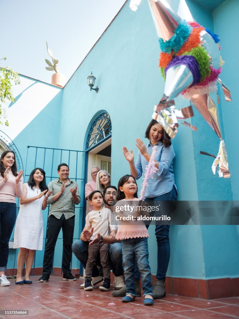 Cute Mexican Girl Hitting Piñata With Stick High-Res Stock Photo