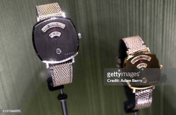 Gucci Grip watches featuring a ruby and a sapphire and a ruby and an emerald are seen on display on the opening day of the 2019 Baselworld luxury...