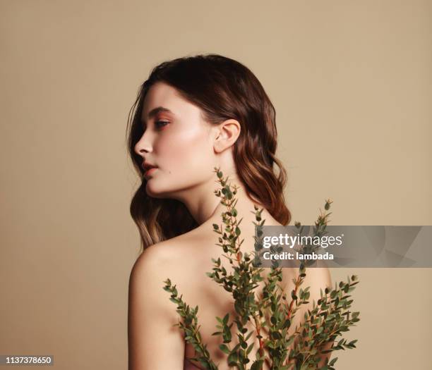 young beautiful girl and plant - beauty product stock pictures, royalty-free photos & images