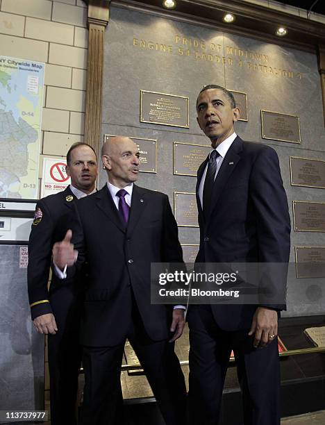 President Barack Obama, right, views a memorial honoring deceased members of the New York City Fire Department during a visit to the headquarters of...