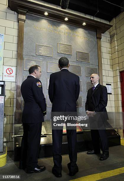 President Barack Obama, center, views a memorial honoring deceased members of the New York City Fire Department during a visit to the headquarters of...