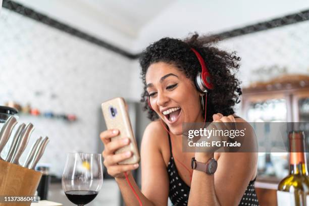 vrouw genieten tijdens het luisteren haar favoriete nummers over smart phone - brazilian dancer stockfoto's en -beelden