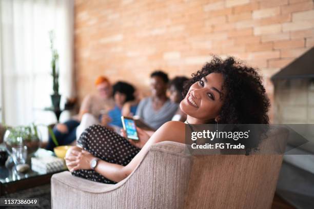 woman portrait using mobile on social gathering at home - reunion social gathering stock pictures, royalty-free photos & images