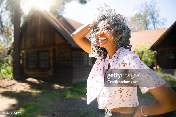 carefree black woman with hand in her hair laughing - hair woman mature grey hair beauty stock pictures, royalty-free photos & images