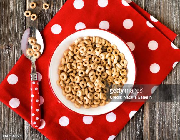 bowl of breakfast cereal and polka dot napkin - cheerios stock-fotos und bilder