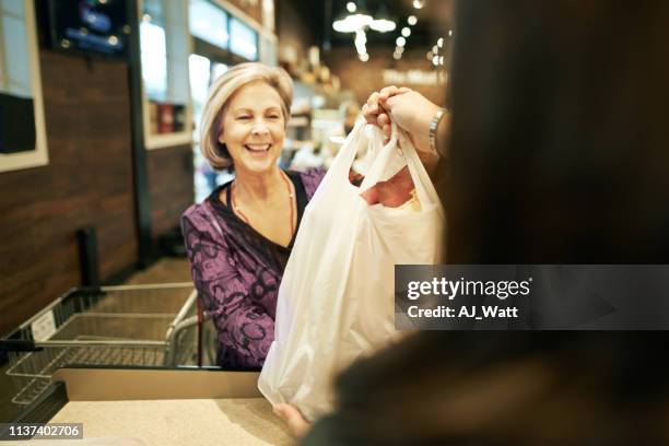 sie verlässt immer mit einem lächeln im gesicht - markt verkaufsstätte stock-fotos und bilder