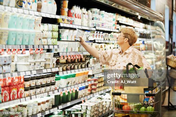 the store that stocks her favourite yoghurt - dairy aisle stock pictures, royalty-free photos & images