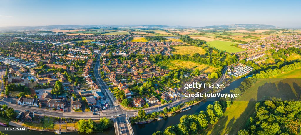 Panorama aérien sur les maisons familiales suburbaines entourent par des champs verts