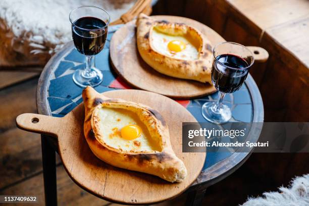 khachapuri served with red wine in a restaurant - georgian stock pictures, royalty-free photos & images