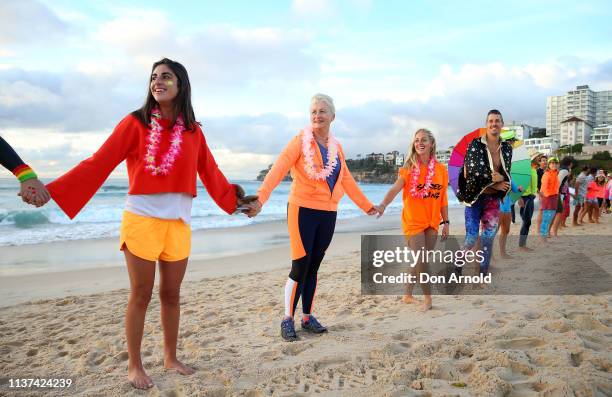 Dr Kerryn Phelps links hands with surfers on the Bondi Beach shoreline on March 22, 2019 in Sydney, Australia. Surfers gather to celebrate five years...