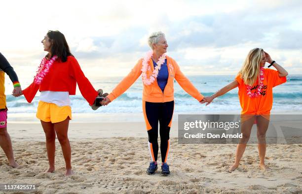 Dr Kerryn Phelps links arms with surfers on the Bondi Beach shoreline on March 22, 2019 in Sydney, Australia. Surfers gather to celebrate five years...
