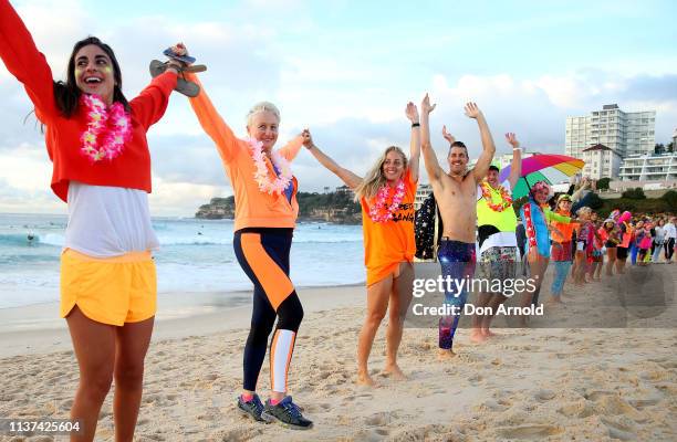 Dr Kerryn Phelps links arms with surfers on the Bondi Beach shoreline on March 22, 2019 in Sydney, Australia. Surfers gather to celebrate five years...