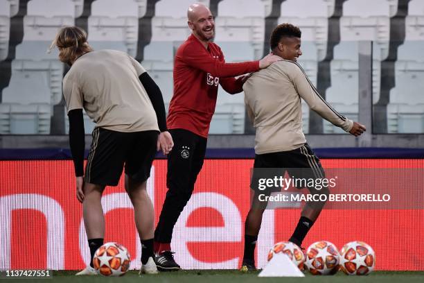 Ajax's Brazilian forward David Neres and Ajax's Dutch coach Erik Ten Hag joke during a training session on April 15, 2019 at the Juventus stadium in...