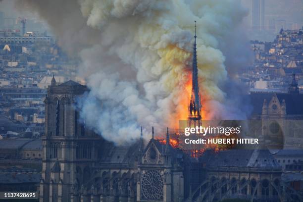 Smoke and flames rise during a fire at the landmark Notre-Dame Cathedral in central Paris on April 15 potentially involving renovation works being...