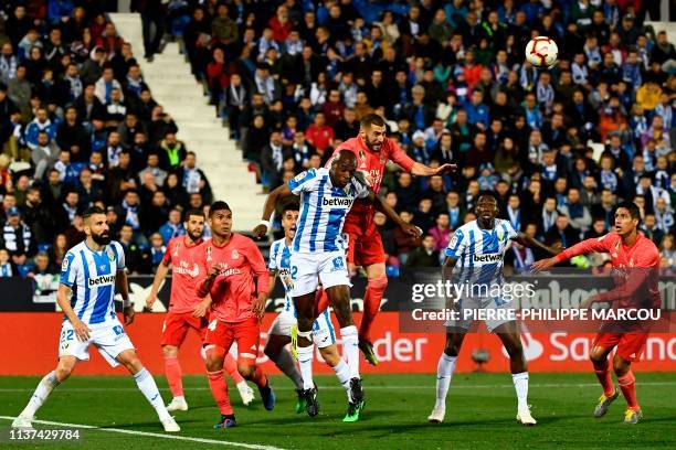 Real Madrid's French forward Karim Benzema and Leganes' Cameroonian defender Allan Nyom jump for the ball during the Spanish league football match...