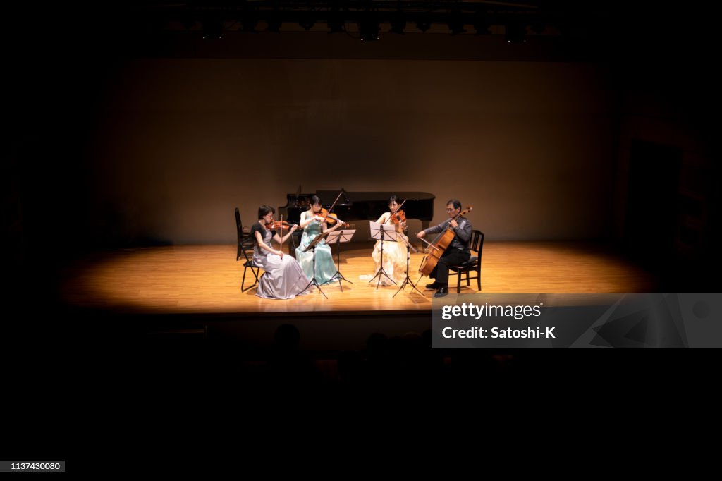 Violinistas y violonchelistas tocando en conciertos de música clásica