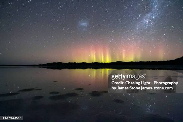 nature's fireworks, bright beams of the aurora australis reflected in water - aurora australis bildbanksfoton och bilder