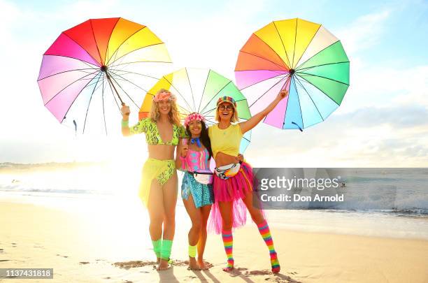 Charlotte Bodell, Jodi Hooker and Liv Phyland pose on Bondi Beach shoreline on March 22, 2019 in Sydney, Australia. Surfers gather to celebrate five...