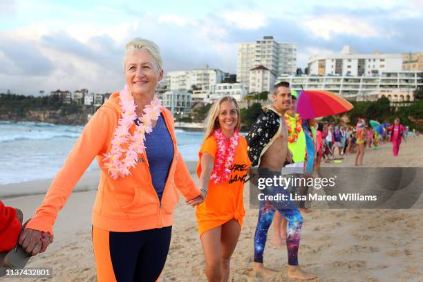 Dr Kerryn Phelps links hands with surfers in solidarity with OneWave at sunrise on Bondi Beach on March 22, 2019 in Sydney, Australia. Surfers gather...