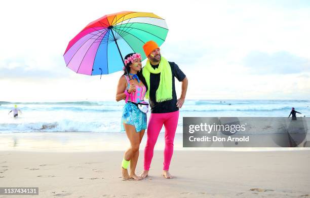 Fluro clad Jodi Hooker and Phil Conway pose on the Bondi Beach shoreline on March 22, 2019 in Sydney, Australia. Surfers gather to celebrate five...