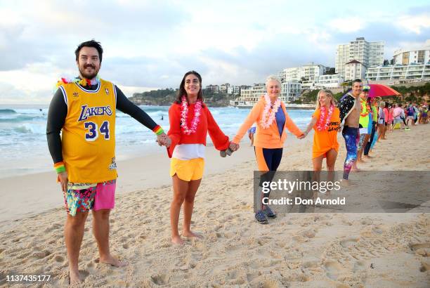 Dr Kerryn Phelps links arms with surfers on the Bondi Beach shoreline on March 22, 2019 in Sydney, Australia. Surfers gather to celebrate five years...