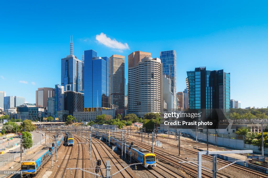 Trains traveling in and out of the city with Melbourne skyscraper downtown in Melbourne, Victoria, Australia.