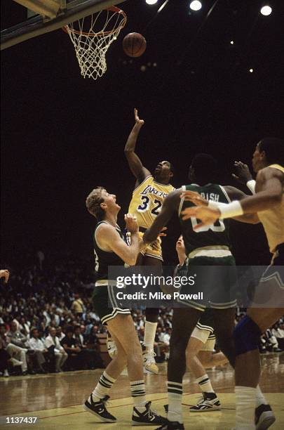 Magic Johnson of the Los Angeles Lakers rebounds over Larry Bird of the Boston Celtics during an NBA Finals game at the Great Western Forum in Los...