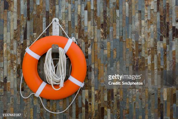 life ring buoy lifesaver on textured wall - lifeboat - fotografias e filmes do acervo