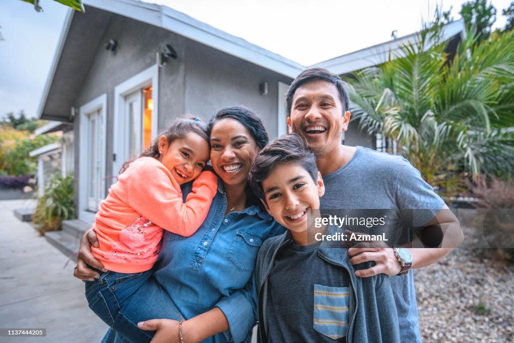 Portrait of happy family against house