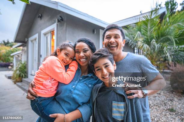 portrait of happy family against house - american dad stock pictures, royalty-free photos & images