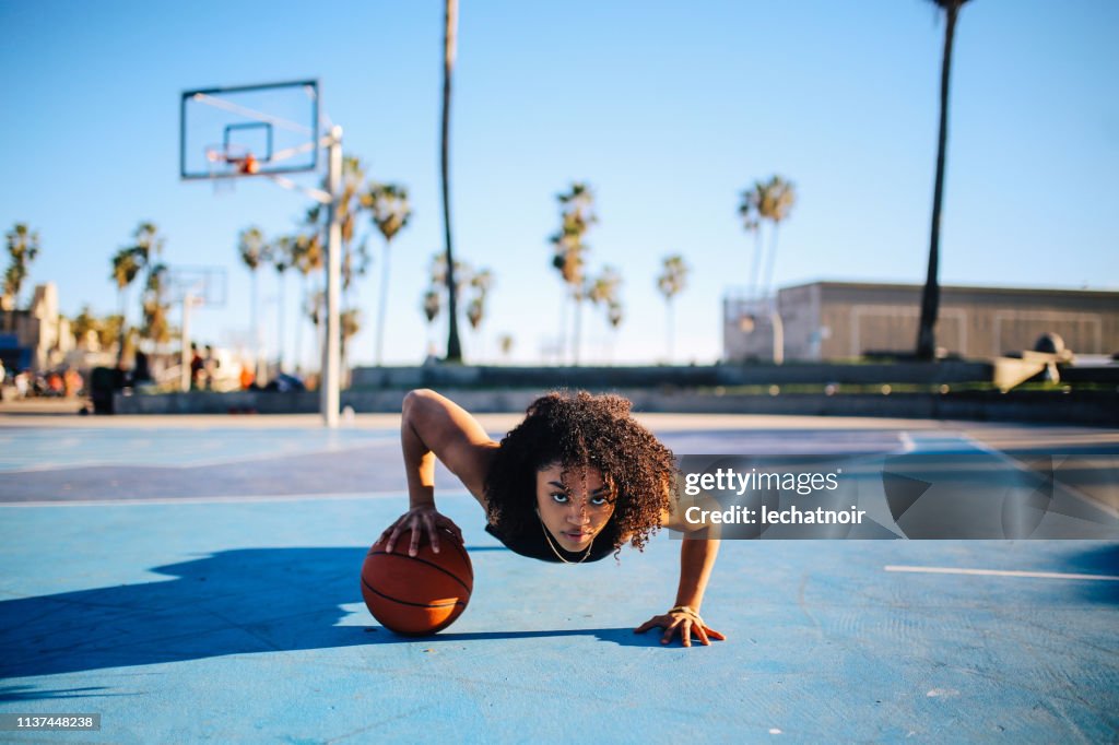 Low angle portrait of a young women doing one hand push ups