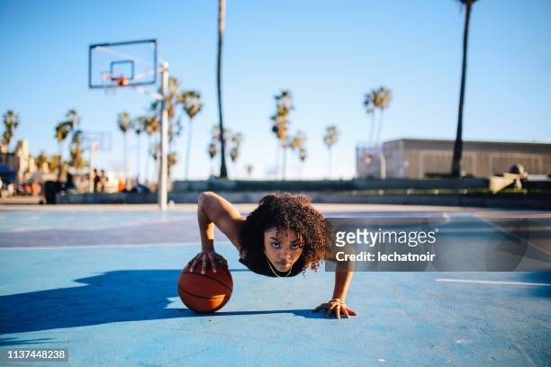 Low angle portrait of a young women doing one hand push ups
