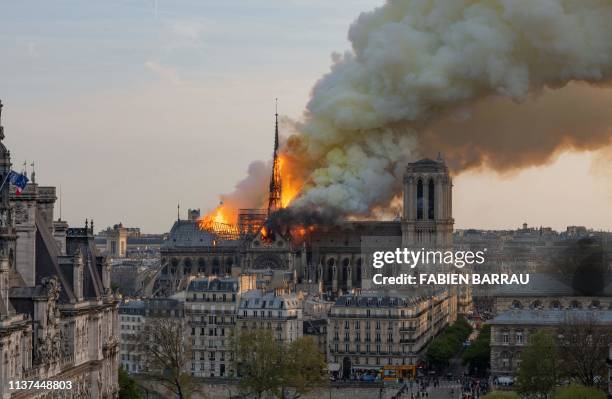 Smoke billows as flames burn through the roof of the Notre-Dame de Paris Cathedral on April 15 in the French capital Paris. A huge fire swept through...