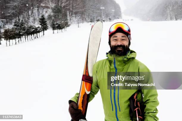 smiling man at the ski resort - man skiing stock pictures, royalty-free photos & images