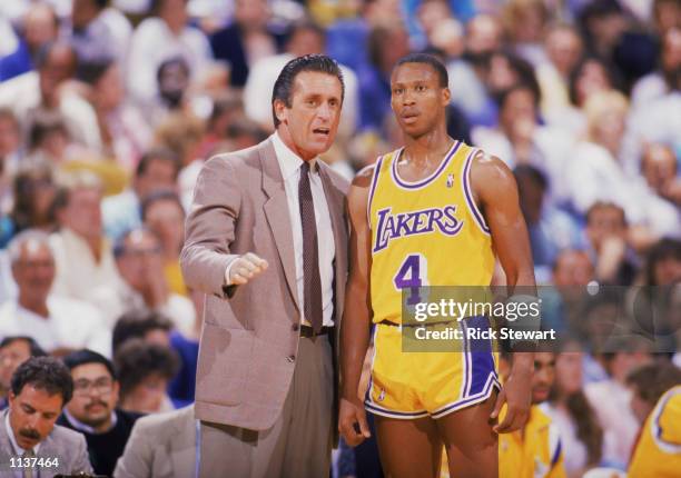 Head coach Pat Riley of the Los Angeles Lakers talks to Byron Scott during an NBA game at the Great Western Forum in Los Angeles, California in 1987.