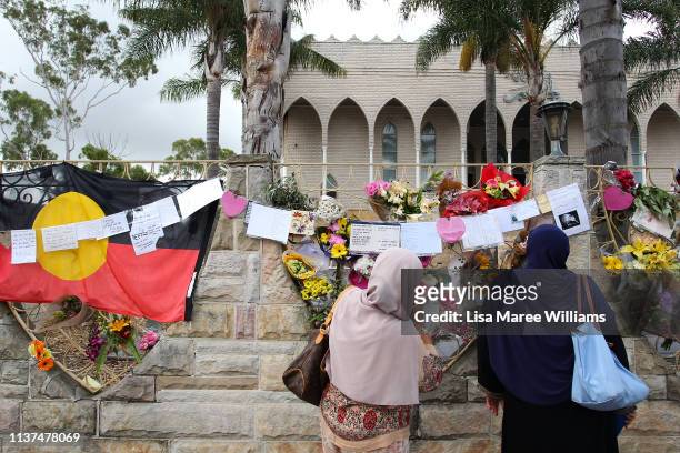 Muslim women read messages placed on the Lakemba Mosque wall in tribute to the victims of the Christchurch attacks on March 22, 2019 in Sydney,...