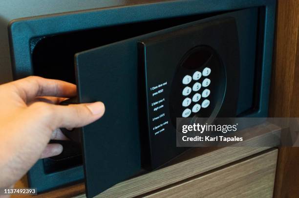 a young person is opening a safety deposit box - safety deposit box stock-fotos und bilder