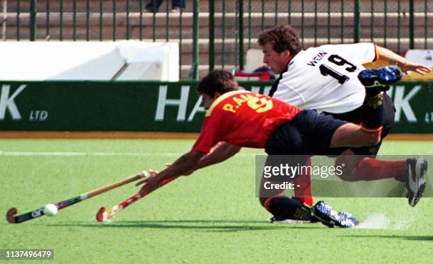Spanish Pablo Amat and German player Christian Wein struggle to get hold of the ball in the first half of the match in 20th field Hockey Champions...