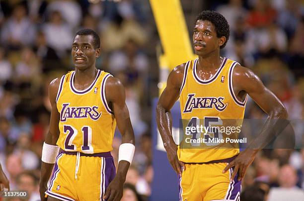 Michael Cooper of the Los Angeles Lakers stands next to A.C. Green during an NBA game at the Great Western Forum in Los Angeles, California in 1988.