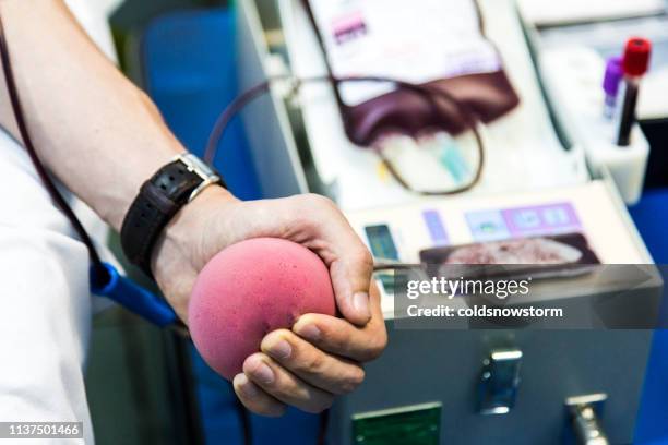 blood donor giving blood in medical clinic - blood donation imagens e fotografias de stock