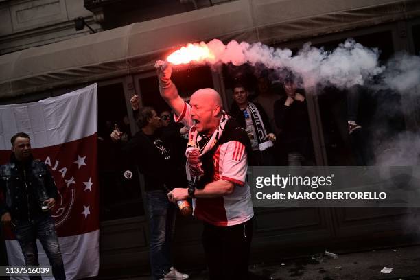 Fan of Ajax holds a flare and cheers as Ajax fans gather in a pub in downtown Turin prior to the UEFA Champions League quarter-final second leg...