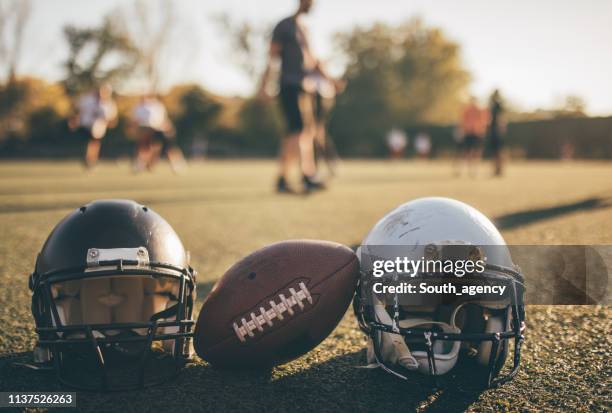 football helmets and ball on grass on training - college american football stock pictures, royalty-free photos & images