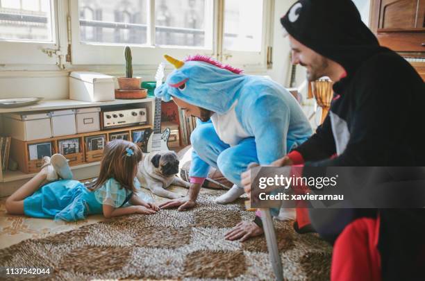 gay couple in costumes by daughter and pug at home - pug unicorn stock pictures, royalty-free photos & images